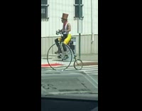 Man in top hat rides vintage bike 