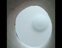 Striped cat tries to grab food from inside hole 