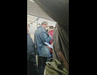 Man jean jacket hugs pet crow on the subway