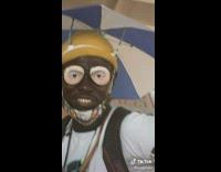 Guy wears umbrella hat and glasses with fake eyes 