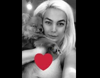 Lady holding dog up by face gets bit