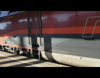 Red train going down tracks makes noise