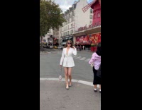 Collab IITW - Woman in white coat Takes Picture in front Moulin Rouge