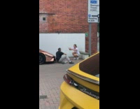 Man black polo sit front sports car pictorial