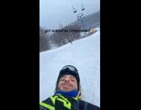 Guy sliding down snow hill on back