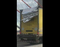 Big Truck Has Part Falling from on Top