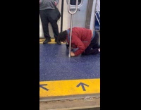 Man lick trail of liquid on train floor
