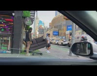 Two guys carry sofa across street in NYC 