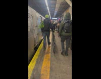 Man in train station has celery in backpack 