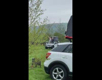 Two women stand on jeep with dog