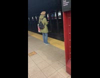 Green jacket lady sprays disinfectant subway platform 