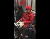 Woman uses typewriter on a subway train