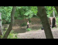 Woman in white crop top and black skirt tiktok dance in the river