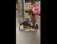 Puppeteer in pink costume performs at station 