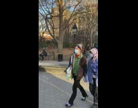 Guy wearing plastic bubble helmet sits bench