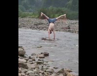 Collab risksIG - Guy does handstand tricks with legs on small piece of land in the middle of river