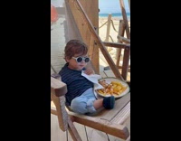 Toddler Chills on Lounge Chair as it Eats