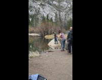 Green shirt older lady balance rock lake