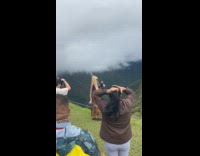 Woman maroon jacket poses front of Mountain