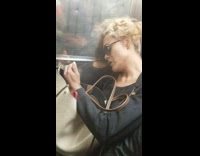 Woman scrolls through phone and chews on lips on subway train