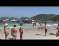 Collab IITW - Woman takes pictures on beach while boat sinks in background