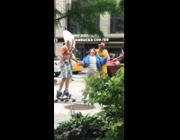 Three men wearing blue shirt, rollerskates, harness, and pasties wave their arms around