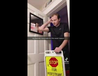 Guy standing at door with stolen sign 