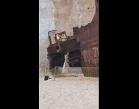 Woman black bikini old shipwreck net fence