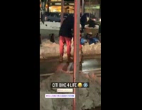 Guy rents blue citibike bicycle night snow