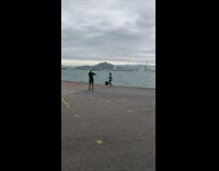 Girl green sweatshirt run pose pier overcast