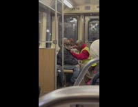Man trims beard of another man inside the train