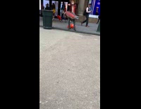 Man cowboy hat red jacket holds big red fake fish and sings on the street