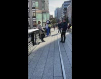 Brown jacket lady sunglasses black pants railing