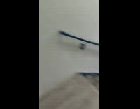 Man struggles to close rooftop door due to thunderstorm