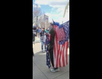 Unwell person covered in american flags yells