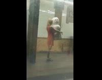 Woman holds giant snowman statue in subway station