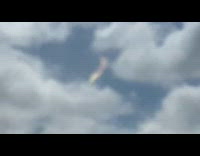 Small rainbow cloud floats top of other clouds 