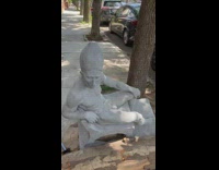 Naked man statue on sidewalk