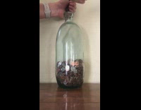 Woman adds coins to glass jar 