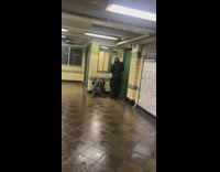 Guy practices clarinet in subway station