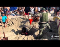 Men dig to save girl stuck in sand