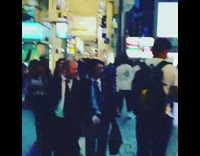 Man in jacket with a bag vlogs on the street