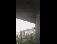 Pink shirt guy haircut sidewalk mirror fence 