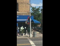 Spiderman sits on yellow pedestrian crossing light 