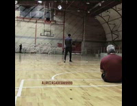 Guy sitting on floor hits basketball into hoop 