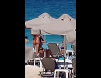 Woman blue bikini brown umbrella beach chairs