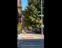 Elderly man sunbathing on sidewalk