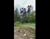 Guy blue dirt bike jump hill success 