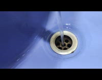 Water from faucet perfectly falls in the sinkhole