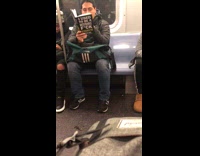 Guy reads book called I Used to be a Miserable Fuck on subway train